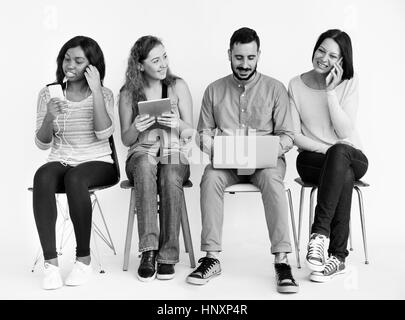 Groupe de personnes à l'aide d'appareils numériques Banque D'Images