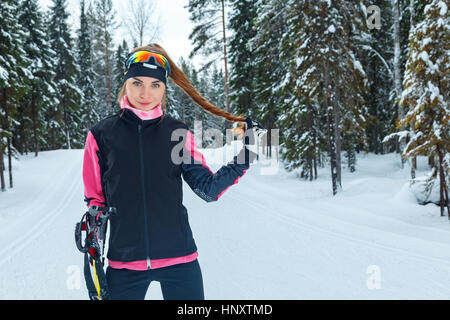 Ski de fond nordique classique femme ski de piste dans les pistes dans la forêt couverte de neige Banque D'Images