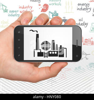 Concept Manufacuring : Hand Holding Smartphone avec de l'huile et du gaz Industrie sur l'affichage Banque D'Images