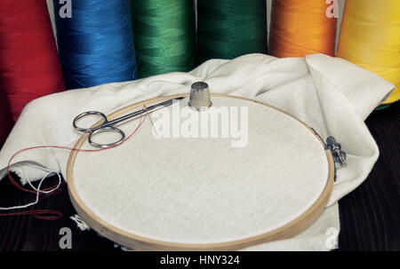 Table ronde en bois avec un linge blanc et d'un ensemble de fils multicolores pour coudre et broder, vintage toning Banque D'Images