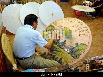 KAOHSIUNG, TAIWAN -- 24 juillet 2016 : un artiste masculin à l'huile peinture sur ombrelles, qui est un art et l'artisanat traditionnel produit par le peuple Hakka chinois Banque D'Images