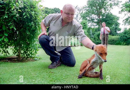 Bruce Lindsay-Smith, avant-plan, et Tony Harman, avec stick, ayant pris un renard dans le jardin. Banque D'Images