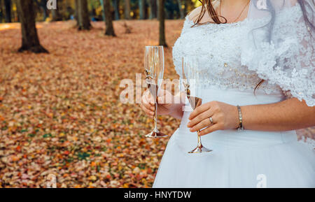 Bride and Groom holding glasses with champagne pendant wedding Banque D'Images