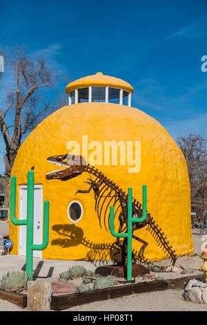 Un dôme jaune structure avec cactus vert metal sculptures et un Tyrannosaurus Rex jette une ombre sur le dôme qui semble être deux de la crea Banque D'Images