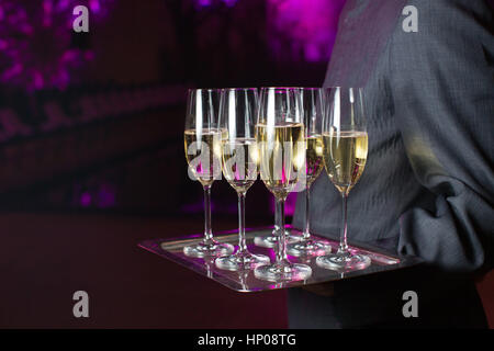 Waiter serving champagne sur un plateau Banque D'Images