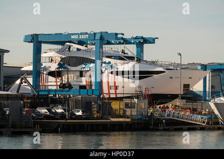 Une grue soulève un Sunseeker yacht de luxe hors de l'eau dans le port de Poole Dorset Banque D'Images