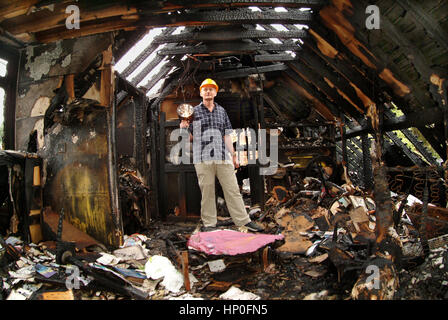 Bill Sweetnam dans sa maison, à Sneyd Park, Bristol, UK, qui avait été gravement endommagé par un incendie Banque D'Images