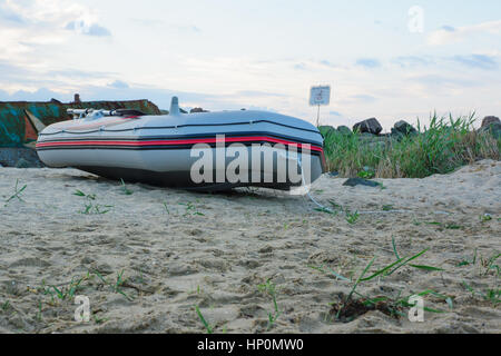 Bateau gonflable s'étend sur la plage de la mer de sable Banque D'Images