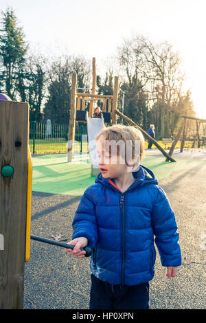 Un jeune garçon de race blanche dans un manteau bleu jouant un xylophone à Swakeleys Ickenham, Parc, London, UK Banque D'Images