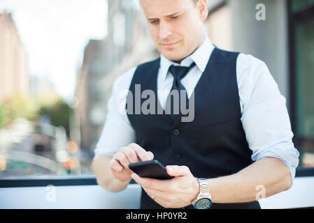 Businessman text messaging with smartphone Banque D'Images