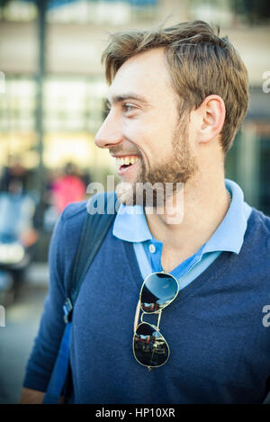 Jeune homme à l'écart et souriant gaiement Banque D'Images