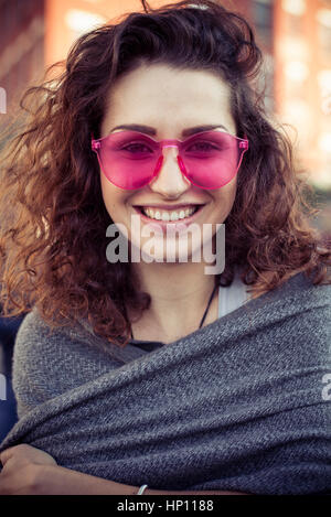 Femme portant des lunettes roses, smiling, portrait Banque D'Images