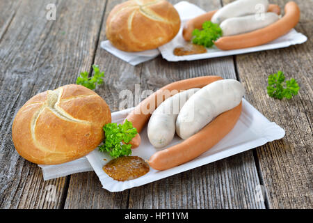 L'alimentation de rue allemand : Bavarian saucisses blanches et des saucisses avec un rouleau frais et doux de la moutarde sur une assiette en carton Banque D'Images