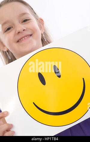 Modèle libération , Maedchen, 6 Jahre, mit lachendem Smileygesicht - fille avec smiley Banque D'Images