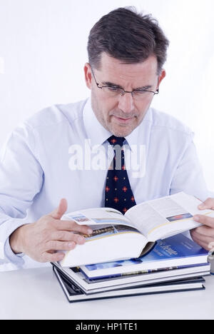 Modèle libération , Mann, 50 +, mit Lesebrille liest ein Buch - Man reading a book Banque D'Images