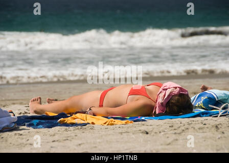 Frau im Bikini sonnt sich am Sandstrand - woman in bikini soleils sur la plage Banque D'Images