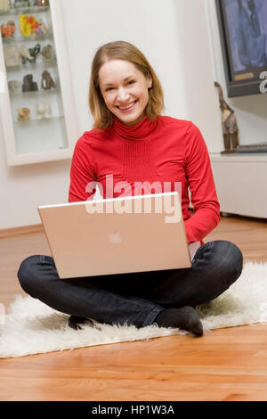 Modèle libération , Junge Frau sitzt mit Laptop in 1-2 - young woman with laptop Banque D'Images