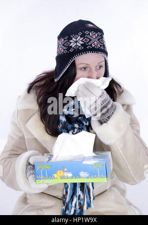 Modèle libération , Frau im schneuzen Winteroutfit muss sich - femme dans winteroutfit avec rhume de cerveau Banque D'Images