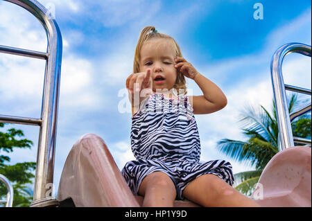 Petite fille va pour un lecteur sur une colline de l'enfant. Banque D'Images