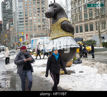 Passant par plaisir dans la nouvelle 'Hippo' ballerine sculpture par l'artiste Danois Bjørn Okholm Skaarup dans Dante Park en face du Lincoln Center de New York le samedi 11 février, 2017. Les 2 et une demi-tonne, plus de 15 pieds de haut sculptures en bronze est inspiré par la danse des hippopotames dans le Disney's 'Fantasia' film et de Degas ballerine des peintures. La sculpture populaire sera à l'affiche jusqu'au 31 juillet 2017. (© Richard B. Levine) Banque D'Images