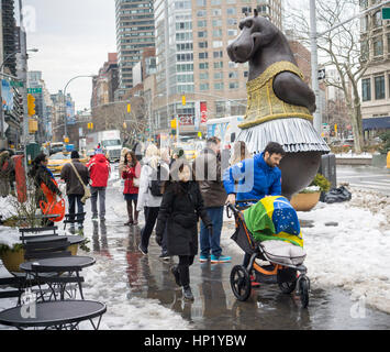 Passant par plaisir dans la nouvelle 'Hippo' ballerine sculpture par l'artiste Danois Bjørn Okholm Skaarup dans Dante Park en face du Lincoln Center de New York le samedi 11 février, 2017. Les 2 et une demi-tonne, plus de 15 pieds de haut sculptures en bronze est inspiré par la danse des hippopotames dans le Disney's 'Fantasia' film et de Degas ballerine des peintures. La sculpture populaire sera à l'affiche jusqu'au 31 juillet 2017. (© Richard B. Levine) Banque D'Images