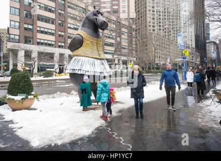 Passant par plaisir dans la nouvelle 'Hippo' ballerine sculpture par l'artiste Danois Bjørn Okholm Skaarup dans Dante Park en face du Lincoln Center de New York le samedi 11 février, 2017. Les 2 et une demi-tonne, plus de 15 pieds de haut sculptures en bronze est inspiré par la danse des hippopotames dans le Disney's 'Fantasia' film et de Degas ballerine des peintures. La sculpture populaire sera à l'affiche jusqu'au 31 juillet 2017. (© Richard B. Levine) Banque D'Images