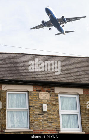 Londres, Royaume-Uni. Un avion survole une maison à Hatton Cross sur l'approche d'atterrir à l'aéroport de Heathrow. Banque D'Images