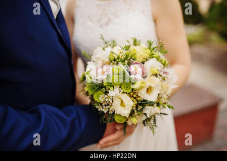 Close up mariage bouquet à mains jeunes mariés. Banque D'Images