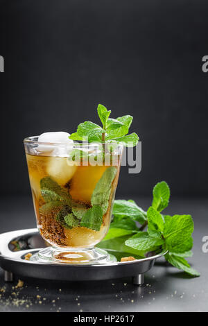 Cocktail Mint Julep avec bourbon, la glace et la menthe en verre sur fond noir Banque D'Images