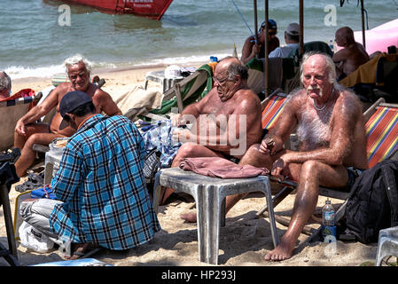 Touristiques mâles matures ayant une vaste corps cheveux couvrant et torse velu, bronzer sur la plage de Pattaya Thaïlande Banque D'Images