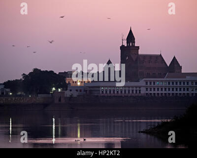 Prag Mahal, le palais et la tour de l'horloge de Bhuj, Hamirsar Lake en premier plan avec les oiseaux tôt le matin, ciel rose, Bhuj, Gujarat Banque D'Images