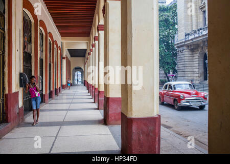 Femme parlant au téléphone et voiture d'époque, scène de rue, dans la rue Agromonte, le quartier de la Habana Vieja, la Habana, Cuba Banque D'Images