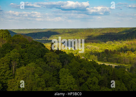 Beau Ciel et nuages au-dessus des collines avec des forêts vertes, couvertes par l'ensoleillement. Gauja, la Lettonie. Banque D'Images