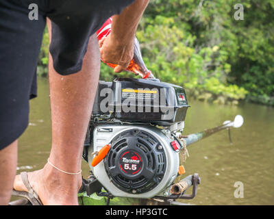 Palmari, Brésil - 6 mai 2016 : habitant de la Amazonia est de verser de l'huile sur le réservoir de carburant bateau à moteur Banque D'Images