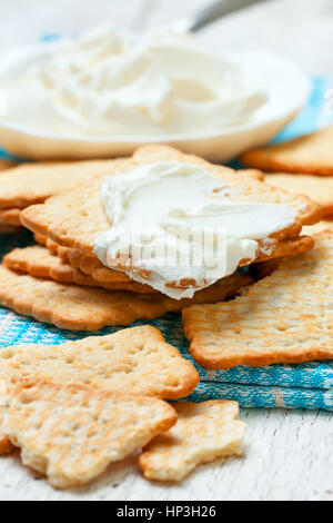 Collation de craquelins et fromage à la crème sur serviette bleu Banque D'Images