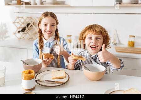 Charmant petit-déjeuner aimant leurs enfants énergiques Banque D'Images