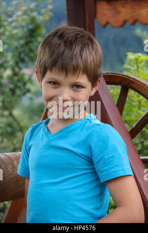 Smiling boy in front of old style bien en bois Banque D'Images