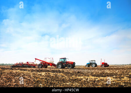 Les tracteurs avec des chars sur le terrain. Les machines agricoles et l'agriculture. Banque D'Images