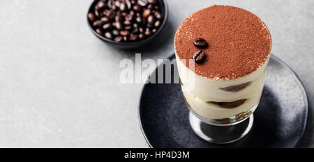 Le Tiramisu, un dessert italien traditionnel en verre sur un fond noir en gris Copy space Banque D'Images