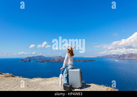 Jeune femme avec parapluie et assurance regarde la mer Banque D'Images