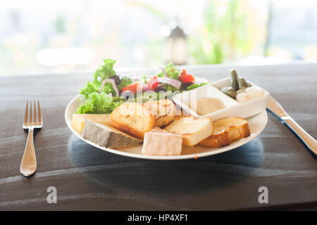 Un fromage français plaque avec de la Tomme, Belkot, et saint Marcellin fromages, salade, moutarde de Dijon, de cornichons et d'échalotes Banque D'Images