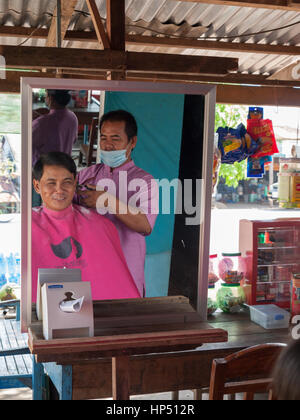Homme avoir couper les cheveux dans un salon de barbier cambodgien Banque D'Images