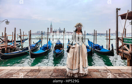Venise, Italie- 198 Février 2012:une femme ina belle robe et masque colombina posant devant des gondoles dock pendant le Carnaval de Venise. Banque D'Images
