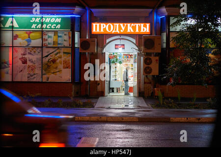 Moscou, Russie - le 21 juillet 2015 : Jeune homme paie de l'argent dans le magasin alimentaire de nuit sur Eniseyskaya street. Texte russe est traduit comme food store. Banque D'Images