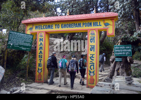 Quatre Trekkers & Guide Sherpa en passant par l'entrée de Ghorepani Poon Hill à l'aube dans le sanctuaire de l'Annapurna, Himalaya, Népal, Asie. Banque D'Images