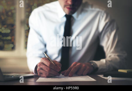 Portrait de la signature de contrat à l'office, travaillant de nuit les heures supplémentaires Banque D'Images