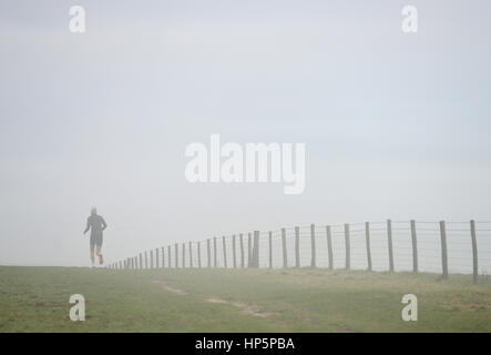 Le Parc National de South Downs, East Sussex. 19 février 2017. Morning Mist entoure un runner sur le parc national des South Downs dans l'East Sussex comme air tropical humide atteint la Grande-Bretagne. © Peter Cripps/Alamy Live News Banque D'Images