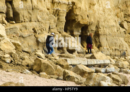 West Bay, Dorset, UK. 19 février 2017. Météo britannique. Deux jeunes visiteurs à la station balnéaire de la baie de l'Ouest risquent leur vie en grimpant sur le terrain à l'East Cliff à West Bay. Au cours des dernières années leur ont été nombreux Glissements et chutes de pierres le long des falaises de West Bay à Burton Bradstock avec un décès en 2012. Crédit photo, Graham Hunt/Alamy Live News Banque D'Images