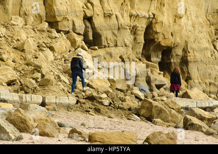 West Bay, Dorset, UK. 19 février 2017. Météo britannique. Deux jeunes visiteurs à la station balnéaire de la baie de l'Ouest risquent leur vie en grimpant sur le terrain à l'East Cliff à West Bay. Au cours des dernières années leur ont été nombreux Glissements et chutes de pierres le long des falaises de West Bay à Burton Bradstock avec un décès en 2012. Crédit photo, Graham Hunt/Alamy Live News Banque D'Images