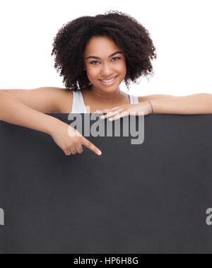 Jeune fille africaine adolescent Smileing tenir le papier blanc et noir montre sur elle. Isolé sur fond blanc. Banque D'Images